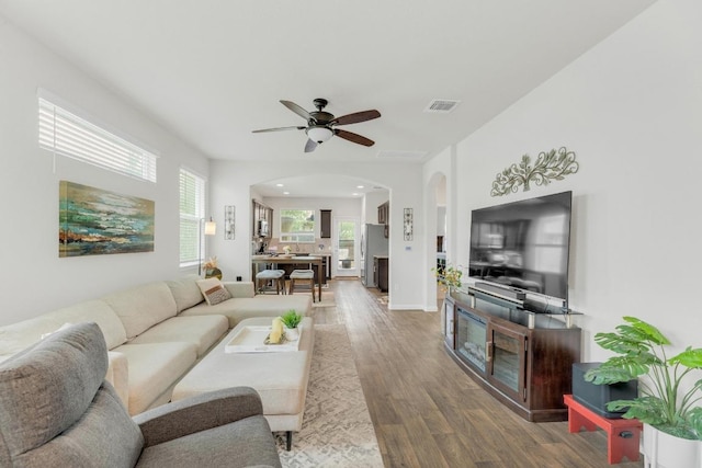 14411 Frankel Loop Unit 32B, Pflugerville, TX 78660 - living area with arched walkways, a ceiling fan, and wood finished floors