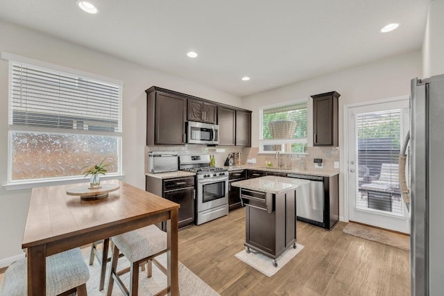 14411 Frankel Loop Unit 32B, Pflugerville, TX 78660 - kitchen featuring appliances with stainless steel finishes, light wood finished floors, dark brown cabinets, tasteful backsplash, and recessed lighting