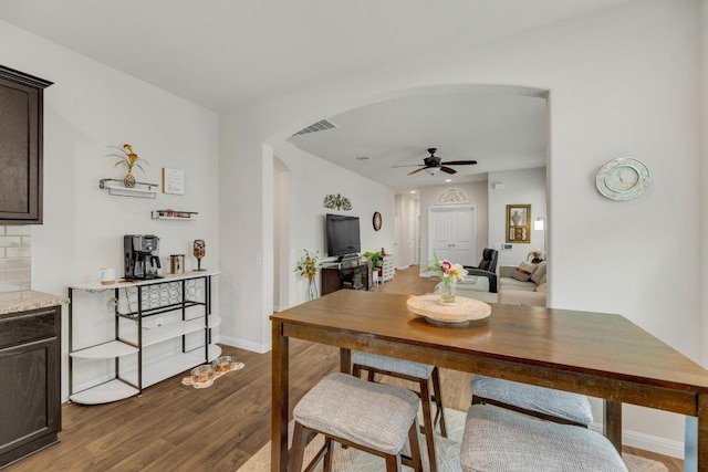 14411 Frankel Loop Unit 32B, Pflugerville, TX 78660 - dining area featuring arched walkways, ceiling fan, and dark wood finished floors
