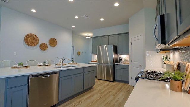 520 Elm Green St, Hutto, TX 78634 - kitchen featuring stainless steel appliances, a sink, light countertops, light wood-type flooring, and recessed lighting