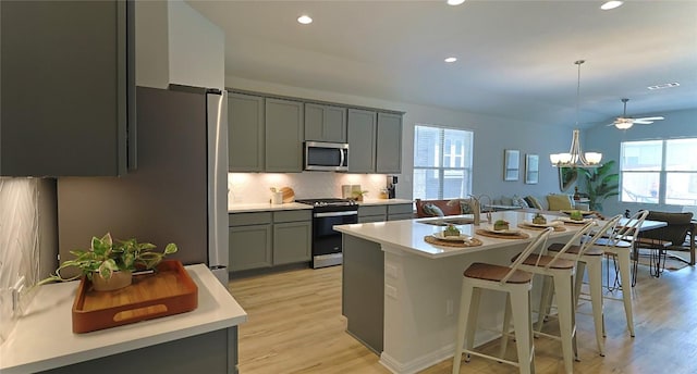 520 Elm Green St, Hutto, TX 78634 - kitchen with stainless steel microwave, range with gas stovetop, gray cabinetry, plenty of natural light, and recessed lighting
