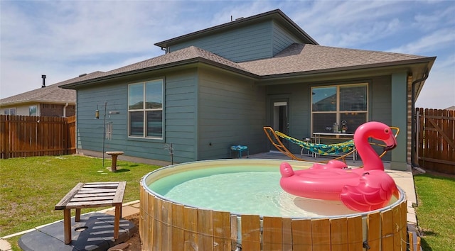 520 Elm Green St, Hutto, TX 78634 - back of property featuring a hot tub, roof with shingles, and a patio