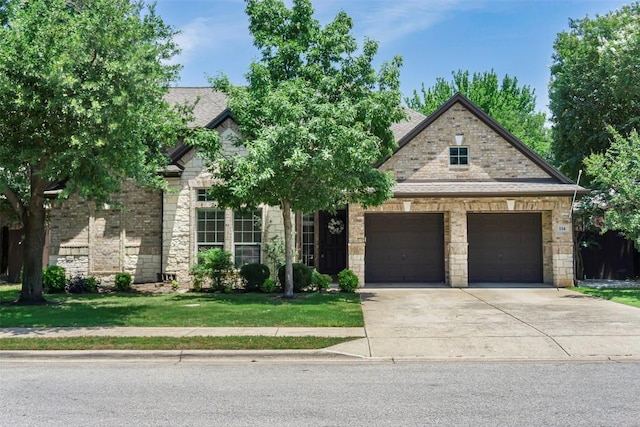 114 Mcbride Ln, Cedar Park, TX 78613 - view of front facade featuring driveway, a front lawn, stone siding, and an attached garage