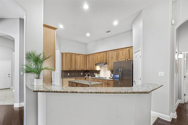 114 Mcbride Ln, Cedar Park, TX 78613 - kitchen with stainless steel fridge with ice dispenser, arched walkways, light stone counters, under cabinet range hood, and recessed lighting