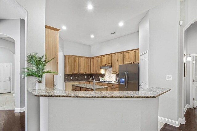 114 Mcbride Ln, Cedar Park, TX 78613 - kitchen featuring stainless steel fridge, arched walkways, light stone countertops, gas stovetop, and recessed lighting