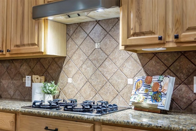 114 Mcbride Ln, Cedar Park, TX 78613 - kitchen with black gas stovetop, range hood, tasteful backsplash, and light stone countertops