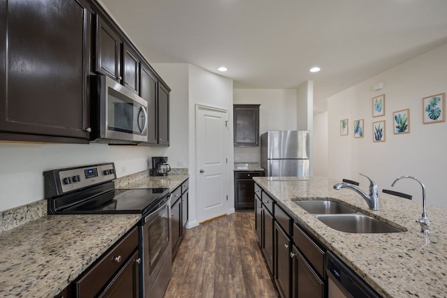 13804 Mark Christopher Way, Manor, TX 78653 - kitchen with stainless steel appliances, a sink, dark wood-style flooring, light stone counters, and recessed lighting