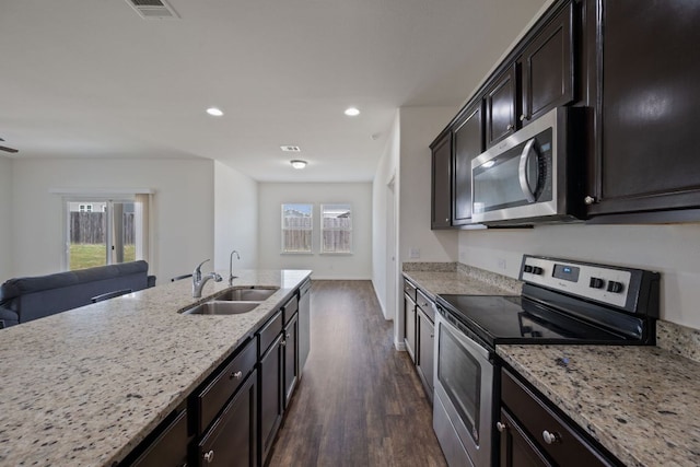 13804 Mark Christopher Way, Manor, TX 78653 - kitchen with appliances with stainless steel finishes, a sink, dark wood-type flooring, light stone countertops, and recessed lighting