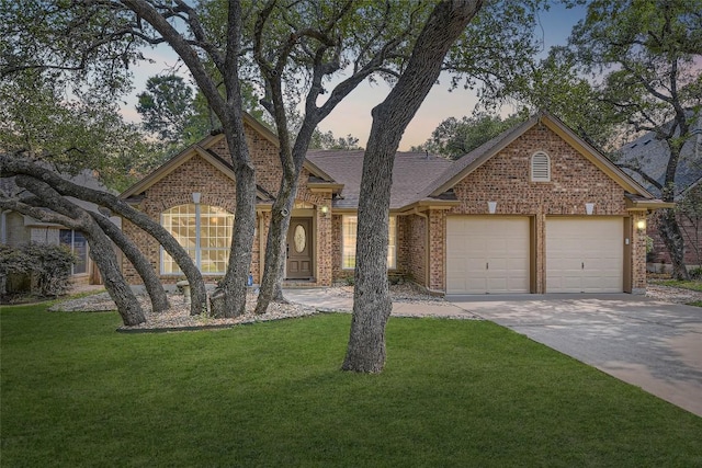6411 Abilene Trl, Austin, TX 78749 - view of front of house featuring a garage, driveway, a front yard, and brick siding