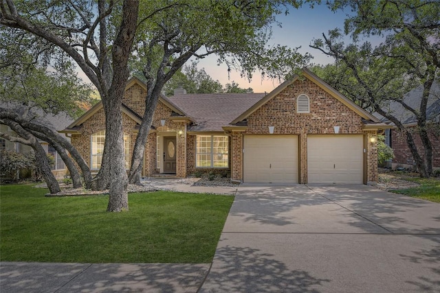 6411 Abilene Trl, Austin, TX 78749 - view of front of home with a garage, driveway, a lawn, and brick siding