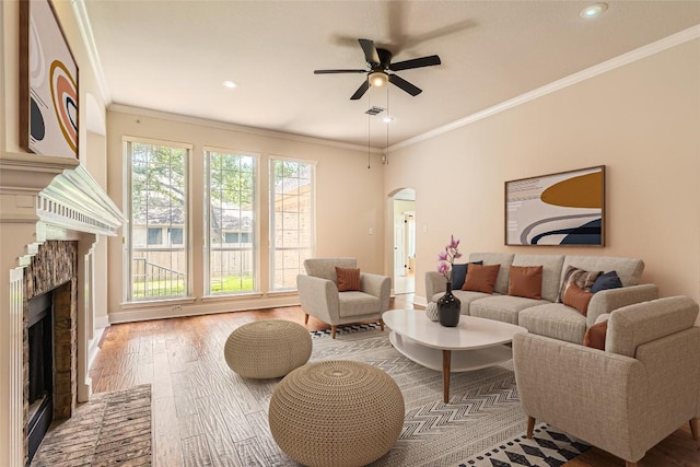 6411 Abilene Trl, Austin, TX 78749 - living area featuring a brick fireplace, hardwood / wood-style floors, crown molding, arched walkways, and ceiling fan