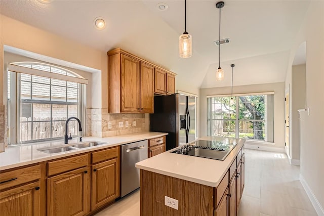 6411 Abilene Trl, Austin, TX 78749 - kitchen featuring appliances with stainless steel finishes, a sink, lofted ceiling, tasteful backsplash, and brown cabinets