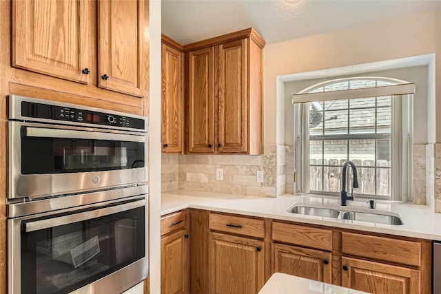 6411 Abilene Trl, Austin, TX 78749 - kitchen featuring double oven, light countertops, and tasteful backsplash