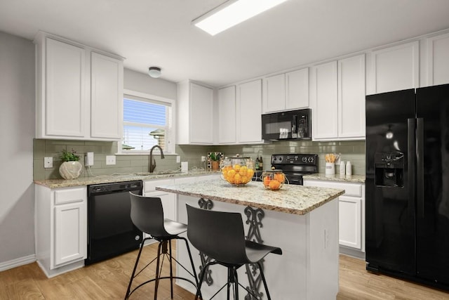 3505 Winding Shore Ln, Pflugerville, TX 78660 - kitchen with black appliances, a sink, tasteful backsplash, and a center island