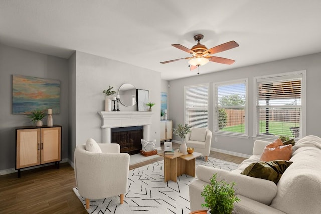 3505 Winding Shore Ln, Pflugerville, TX 78660 - living area featuring wood finished floors, baseboards, ceiling fan, and a fireplace with raised hearth