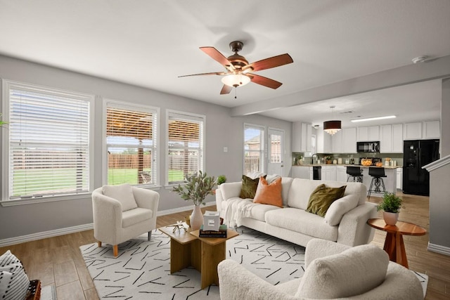 3505 Winding Shore Ln, Pflugerville, TX 78660 - living area featuring baseboards, ceiling fan, and light wood-style flooring