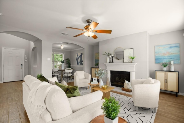 3505 Winding Shore Ln, Pflugerville, TX 78660 - living area with arched walkways, wood finished floors, a ceiling fan, and a fireplace