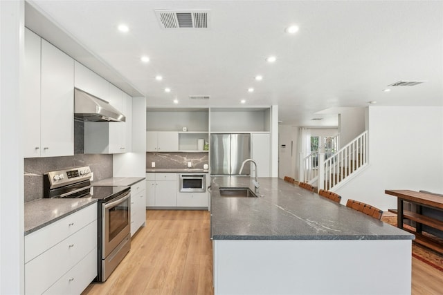 11208 Midbury Ct, Austin, TX 78748 - kitchen featuring stainless steel appliances, under cabinet range hood, open shelves, backsplash, and a large island with sink