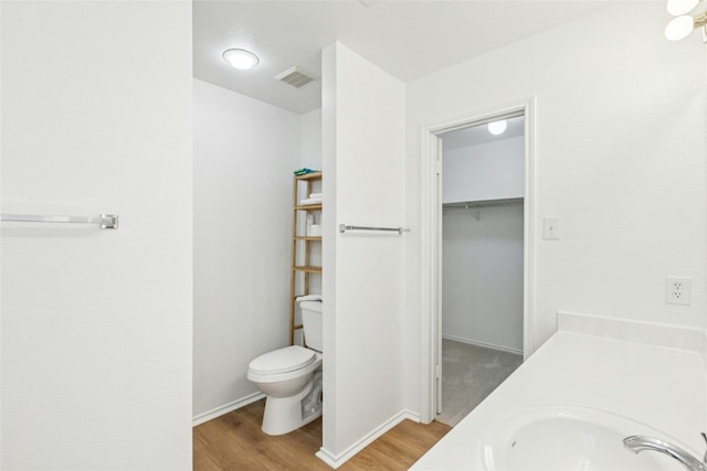 11208 Midbury Ct, Austin, TX 78748 - bathroom with wood finished floors, vanity, and a walk in closet