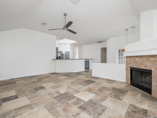 2424 Emmett Pkwy, Austin, TX 78728 - unfurnished living room with a ceiling fan, a fireplace with flush hearth, lofted ceiling, and light stone finish flooring