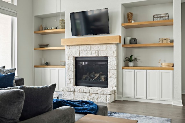 17720 Cain Clearing Pass, Austin, TX 78738 - living room with wood finished floors, built in features, and a stone fireplace
