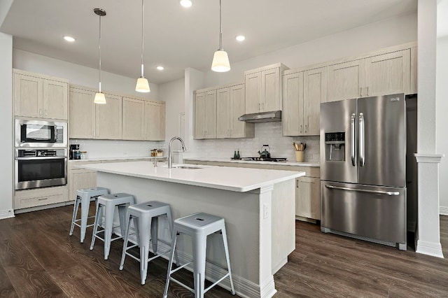 17720 Cain Clearing Pass, Austin, TX 78738 - kitchen with stainless steel appliances, dark wood-style floors, decorative backsplash, a breakfast bar area, and under cabinet range hood