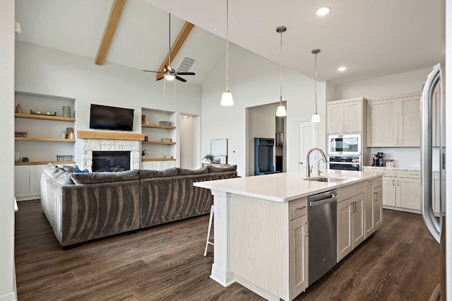 17720 Cain Clearing Pass, Austin, TX 78738 - kitchen featuring stainless steel appliances, open floor plan, dark wood finished floors, a stone fireplace, and high vaulted ceiling
