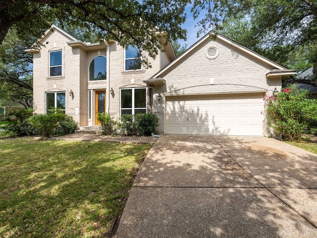 2009 Saint Andrews Dr, Round Rock, TX 78664 - traditional home featuring concrete driveway, a garage, a front yard, and brick siding