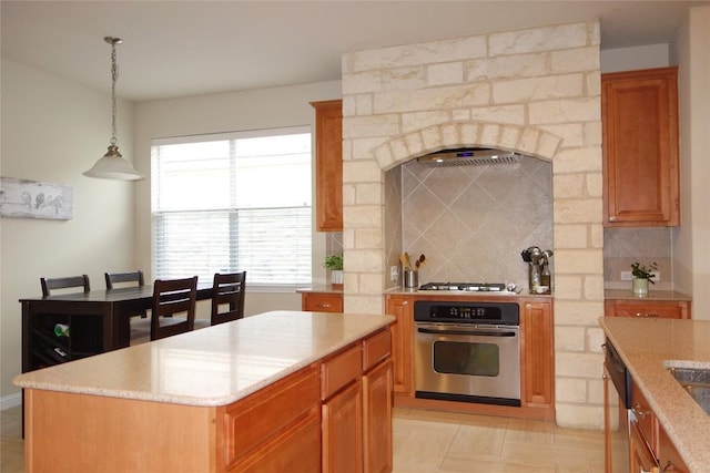 3707 Tall Cedars Rd, Cedar Park, TX 78613 - kitchen with stainless steel appliances, backsplash, hanging light fixtures, a center island, and brown cabinetry