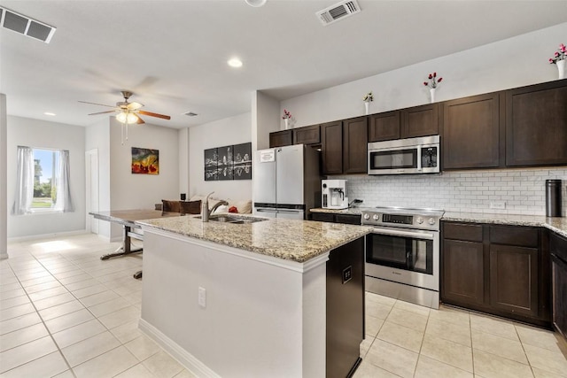 9502 Whisper Willow Blvd, Manor, TX 78653 - kitchen with stainless steel appliances, a sink, light tile patterned floors, backsplash, and recessed lighting