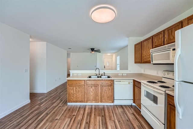 12404 Campana Dr, Del Valle, TX 78617 - kitchen featuring white appliances, a peninsula, wood finished floors, brown cabinetry, and ceiling fan
