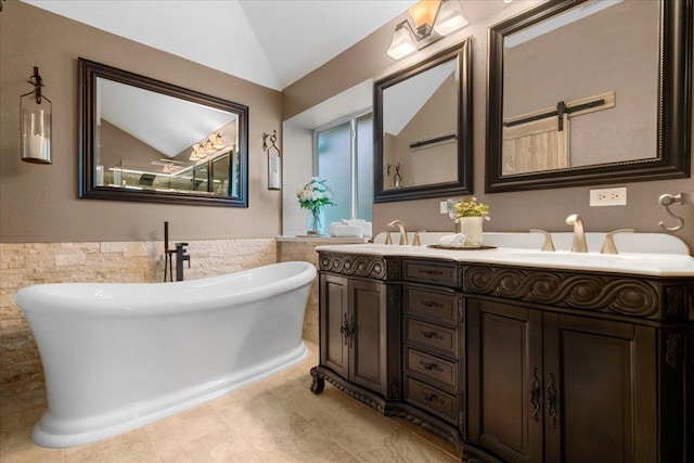 509 Oak Park Dr, Round Rock, TX 78681 - full bath with tile walls, double vanity, a freestanding bath, tile patterned flooring, and vaulted ceiling