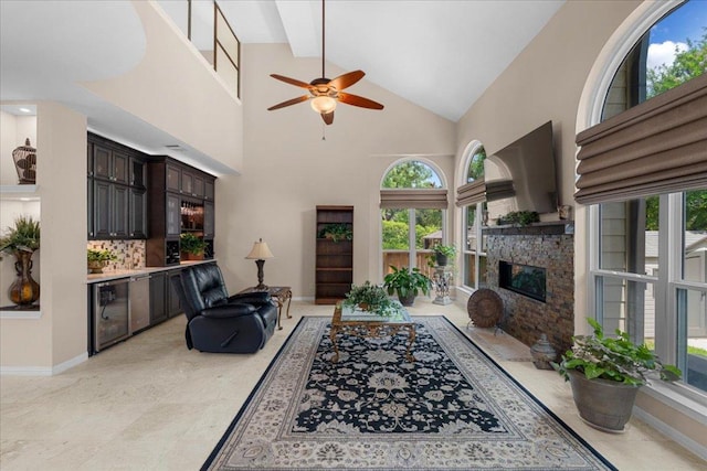 509 Oak Park Dr, Round Rock, TX 78681 - living room with a ceiling fan, a stone fireplace, high vaulted ceiling, and baseboards