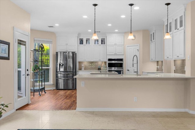 509 Oak Park Dr, Round Rock, TX 78681 - kitchen with stainless steel appliances, a sink, tasteful backsplash, white cabinetry, and glass insert cabinets