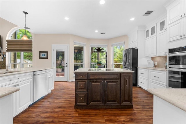 509 Oak Park Dr, Round Rock, TX 78681 - kitchen featuring appliances with stainless steel finishes, dark wood-style floors, light countertops, white cabinets, and glass insert cabinets