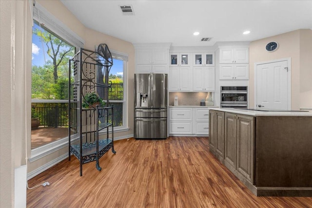 509 Oak Park Dr, Round Rock, TX 78681 - kitchen with appliances with stainless steel finishes, wood finished floors, light countertops, white cabinetry, and recessed lighting