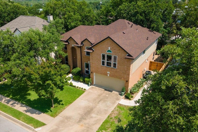 509 Oak Park Dr, Round Rock, TX 78681 - view of front of property featuring a garage, driveway, a front yard, roof with shingles, and a chimney