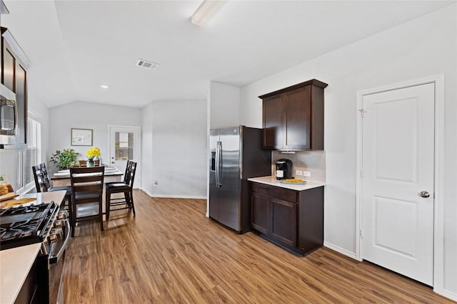 1003 Ascari Ct, Hutto, TX 78634 - kitchen with stainless steel appliances, dark brown cabinets, light wood-type flooring, light countertops, and baseboards