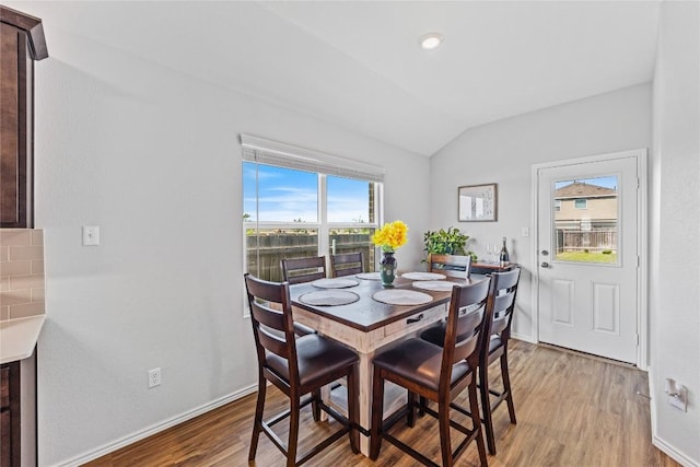 1003 Ascari Ct, Hutto, TX 78634 - dining room featuring lofted ceiling, light wood finished floors, and baseboards