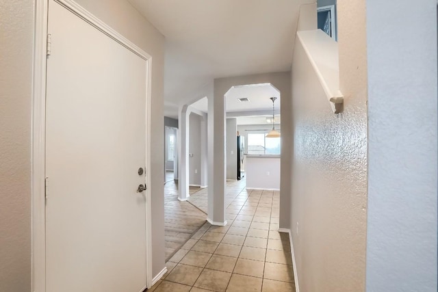 9001 China Rose Dr, Austin, TX 78724 - hallway featuring light tile patterned floors and arched walkways