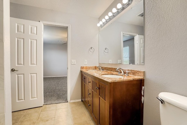 9001 China Rose Dr, Austin, TX 78724 - bathroom with double vanity, tile patterned flooring, toilet, and baseboards