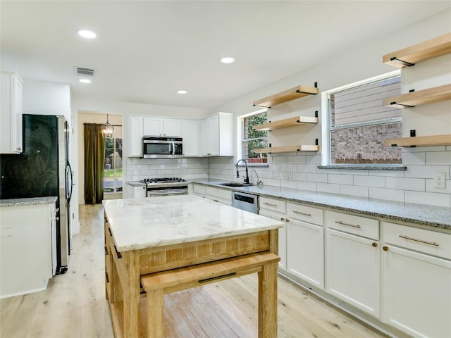 4109 Moss Hollow Dr, Round Rock, TX 78681 - kitchen with stainless steel appliances, open shelves, a sink, white cabinets, and recessed lighting