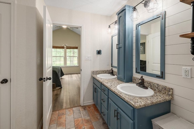 20217 Engelmann Ln, Manor, TX 78653 - ensuite bathroom featuring double vanity, baseboards, and stone finish floors
