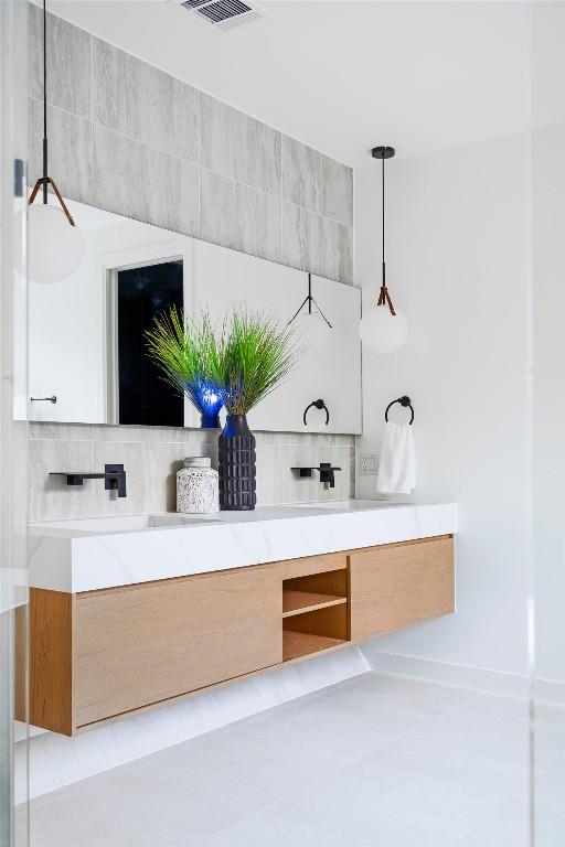 2807 Garwood St, Austin, TX 78702 - bathroom with vanity, backsplash, baseboards, and tile patterned flooring