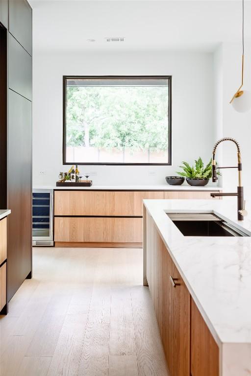 2807 Garwood St, Austin, TX 78702 - kitchen with a sink, modern cabinets, wine cooler, and light stone counters