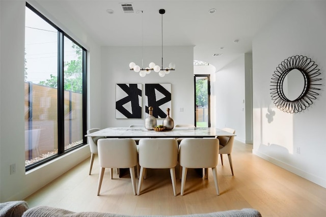 2807 Garwood St, Austin, TX 78702 - dining space with light wood-type flooring, a chandelier, and baseboards