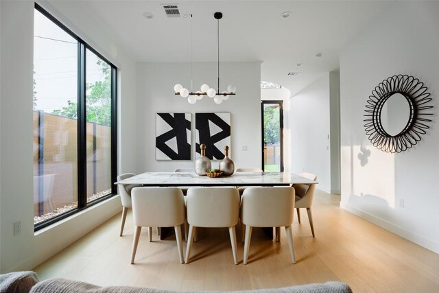 2807 Garwood St, Austin, TX 78702 - dining space featuring light wood-style floors, a chandelier, and baseboards