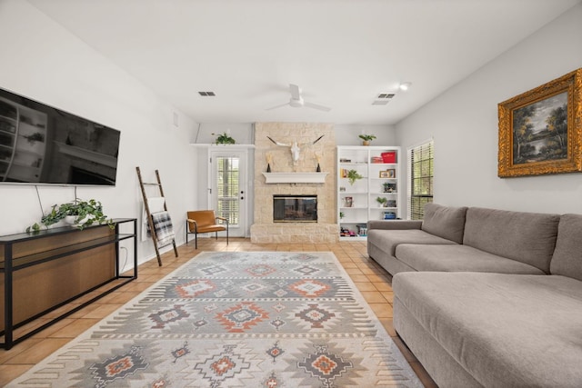 10805 Flashpoint Ct, Austin, TX 78736 - living room with tile patterned floors, a ceiling fan, and a stone fireplace