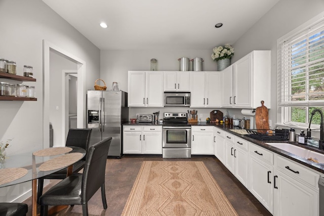 10805 Flashpoint Ct, Austin, TX 78736 - kitchen featuring stainless steel appliances, dark countertops, a sink, white cabinetry, and recessed lighting