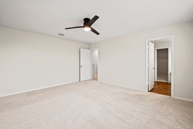 128 Rock Nettle, New Braunfels, TX 78130 - unfurnished bedroom with light colored carpet, baseboards, a walk in closet, and a ceiling fan